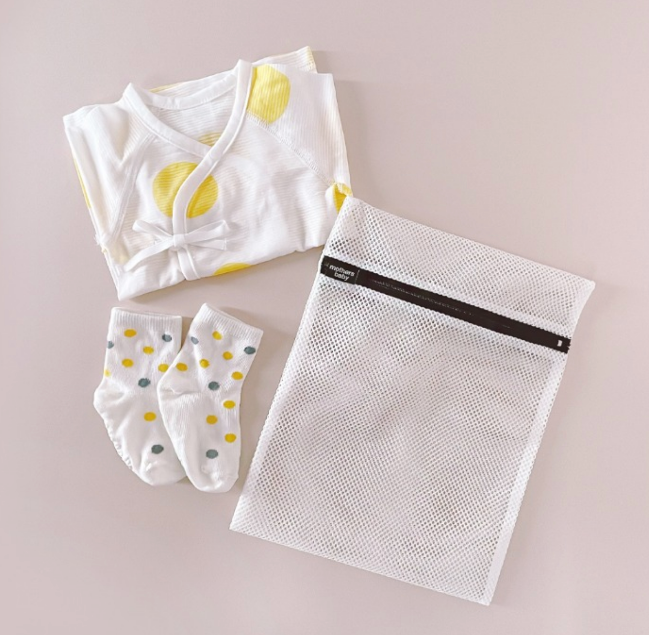 Multipurpose laundry net bag with zipper, baby socks, and white clothing on a light surface. Size: 225 x 30 cm. Made in Korea.