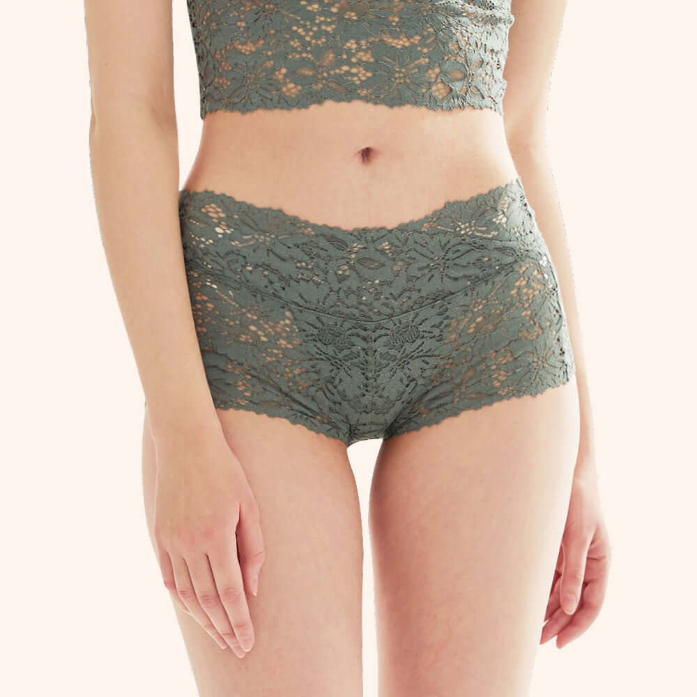 Pregnant woman wearing green flower lace design panties for comfortable support during pregnancy.